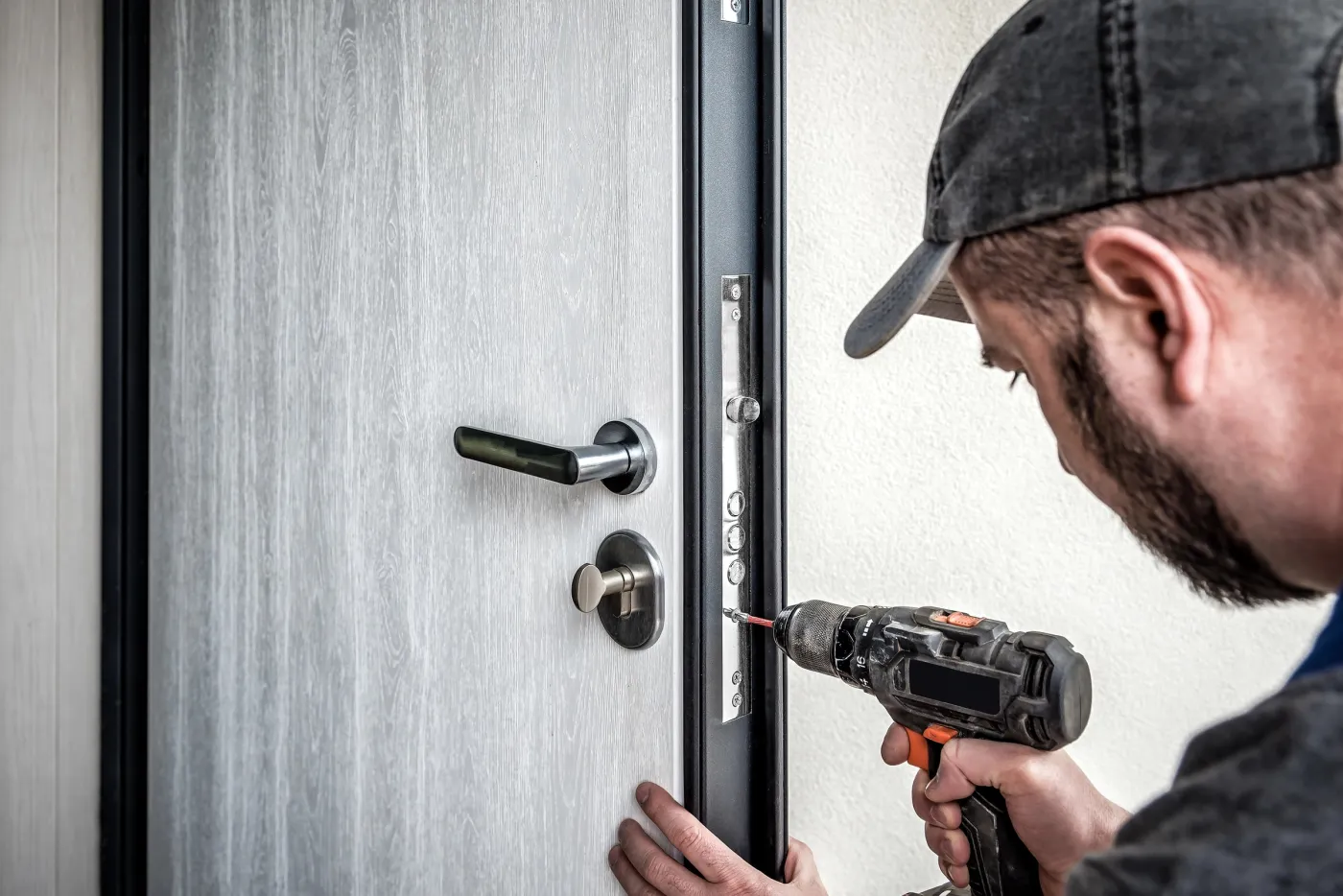 Serrurier fixant une serrure sur la porte d'un pavillon de Villepreux (78450)